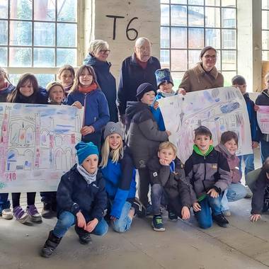 ein Gruppenbild der Hortkinder mit Erziehern und Herrn Dr. Dreihaupt; die Kinder halten Plakate zum Thema Industriekultur